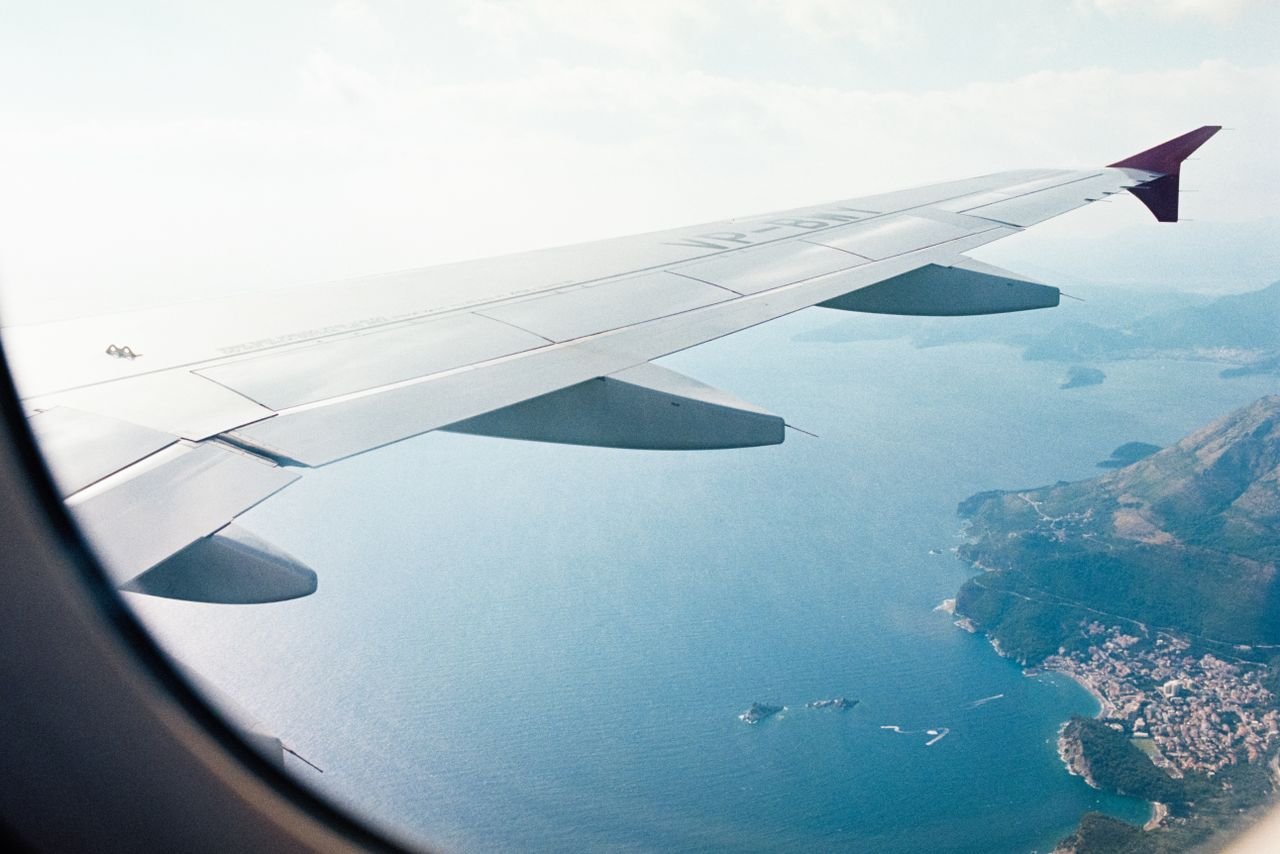 Aerial view from an airplane window of a scenic Mediterranean coastline.